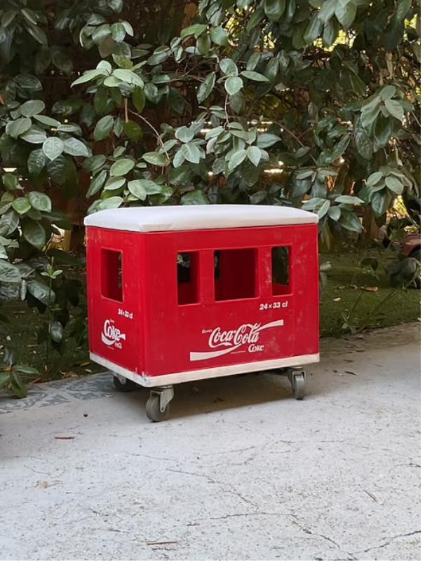 Cocapouf rouge : caisse de bouteilles Coca-Cola transformée en pouf-coffre roulant